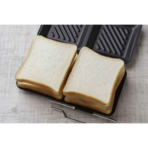 ホットサンドメーカー グリルdeクック ホットサンドパン 持ち手がついたホットサンドメーカーの上面、焦げ目がついた食パンが焼かれている様子。