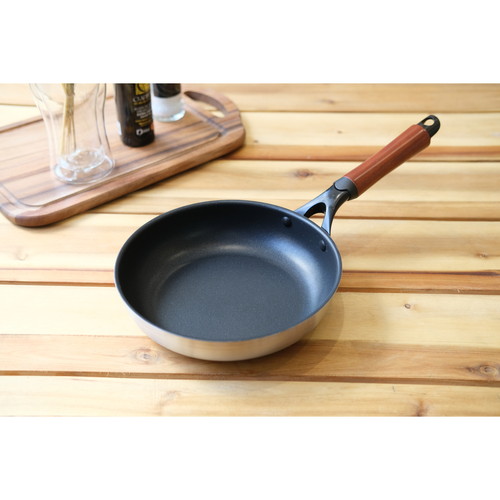 2層鋼ダイヤモンドコートフライパン24cm　ファストクック 表面が光沢のある深い色合いのフライパンが置かれている様子