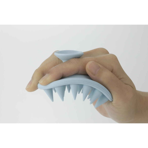 シリコンシャンプーブラシ　大　パステルブルー ラウンド型のブラシが横向きに置かれた状態、軽やかなパステルブルーの色合いが際立つ。