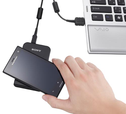非接触ICカードリーダーライター　パソリ 白い円形の本体が斜め上から見える状態で、黒いUSBケーブルが横に添えられている