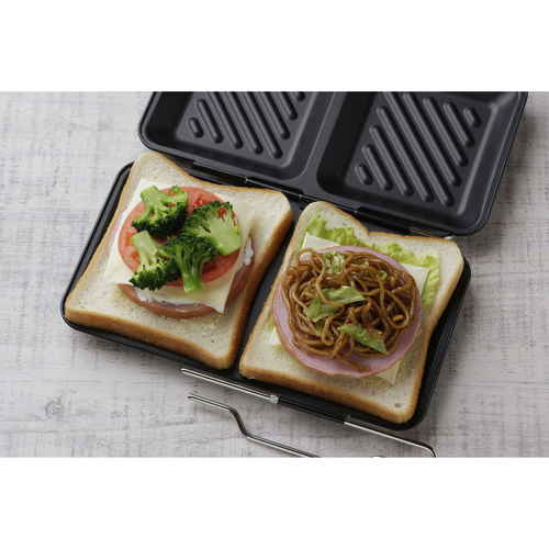 ホットサンドメーカー グリルdeクック ホットサンドパン 製品の全体像が見える状態、取っ手が付いたデザインで、焼き目がついたホットサンドが真ん中に配置されている。