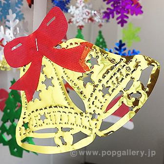 バリュークリスマスプリーツハンガー 鮮やかな色合いのハンガーが木製ラックに掛けられ、クリスマスの装飾が施された様子