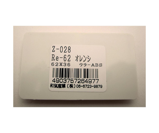 リフレクター　Re-62　オレンジ　横62mm×縦36mm×厚さ7mm 鮮やかなオレンジ色のリフレクターが横向きで置かれている状況