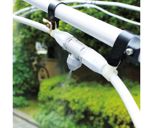ミストアーチ　シングル　5ノズル 上部から下に向けて水を噴出しているノズルの並びと、周囲の緑豊かな背景が見える状態