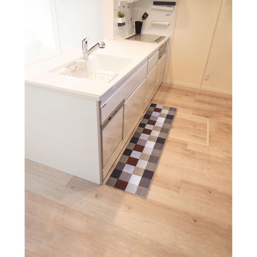 Lugnキッチンマット45X180cm　BRO/ブロック 明るい色合いのブロック模様が広がる長方形のマットが、木製の床に敷かれている様子。