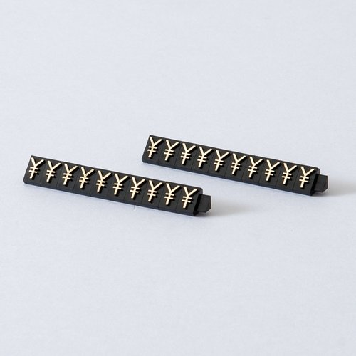 陳列備品 ニュープライスキューブ補充L用(20粒) 黒/金 ￥マーク 友屋 黒と金の配色で、金の「￥」マークが目立つ複数のカプセルが並べられた状態。