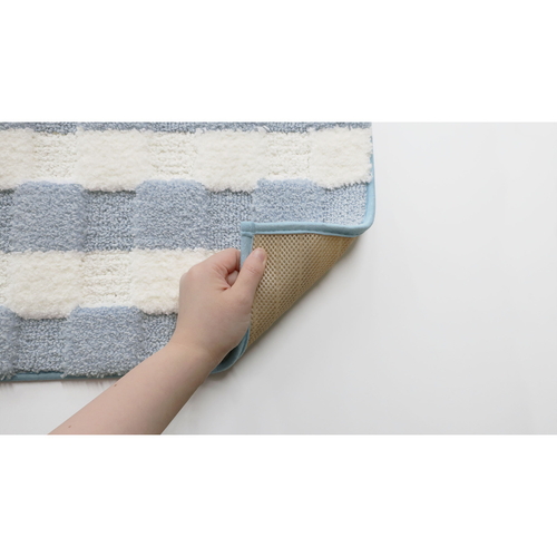 瞬間吸水!しゃりさらバスマット　45X60cm　ブルー 明るい青色のバスマットが、洗面所の床に広げられた状態で見える。