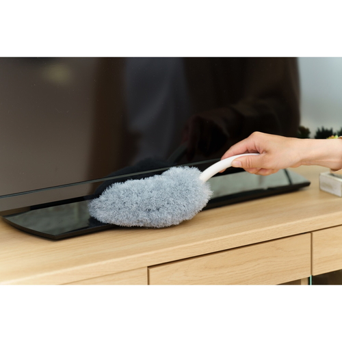 ほこり取り　バスボンくん　ホコリガードハンディモップ 白いハンドルを持つモップが立て置かれている様子、モップ部分は柔らかい繊維で覆われている。
