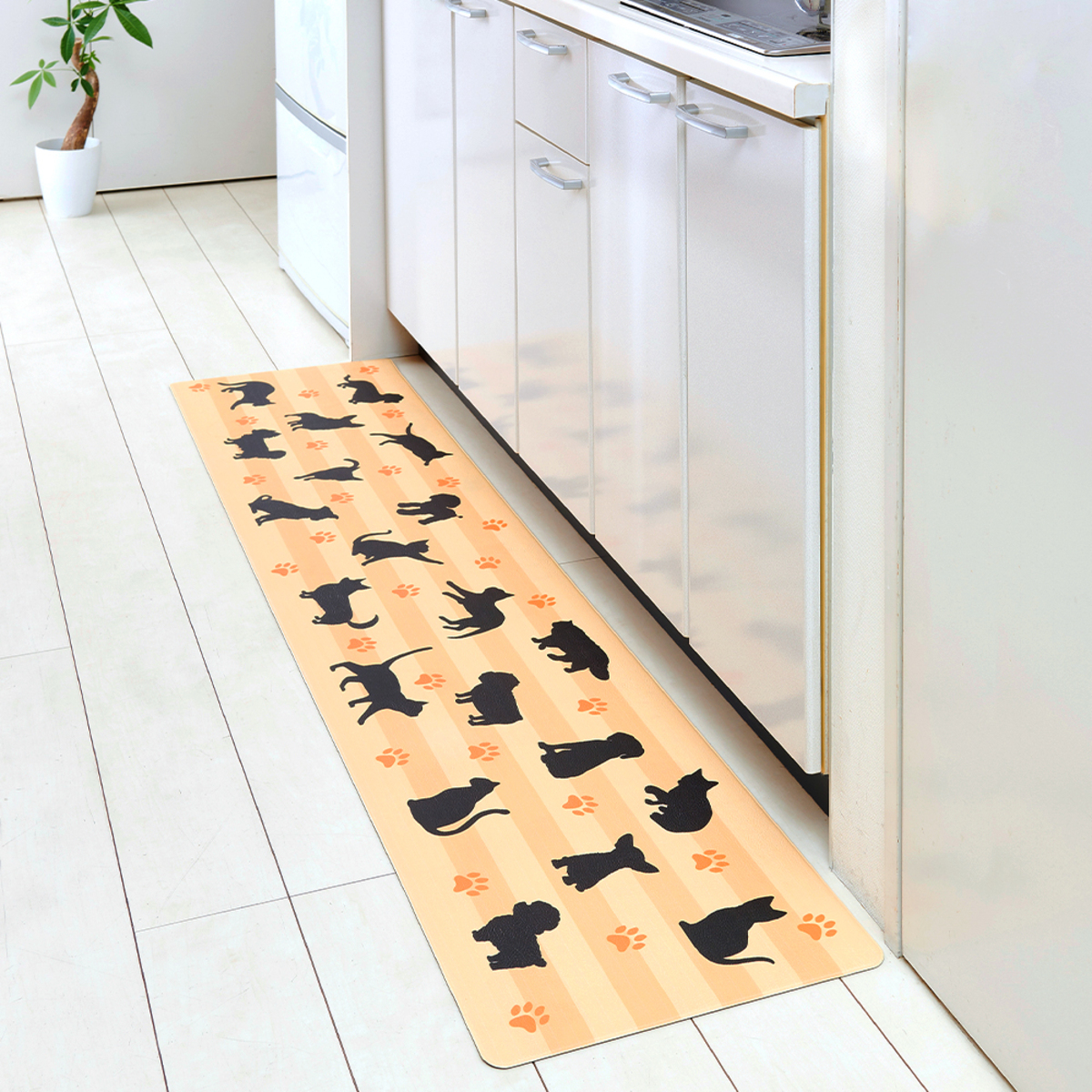 サッと拭けるキッチンマット40x180　イヌネコ 白地にカラフルな犬と猫のデザインが施されたキッチンマットが広げられている様子