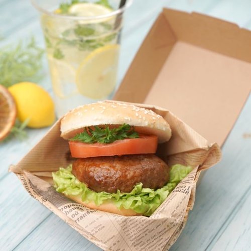 軽食容器 ハンバーガートレー未晒 東罐興業 [ケース販売] 白いトレーにセットされたハンバーガーの一部が見える状態