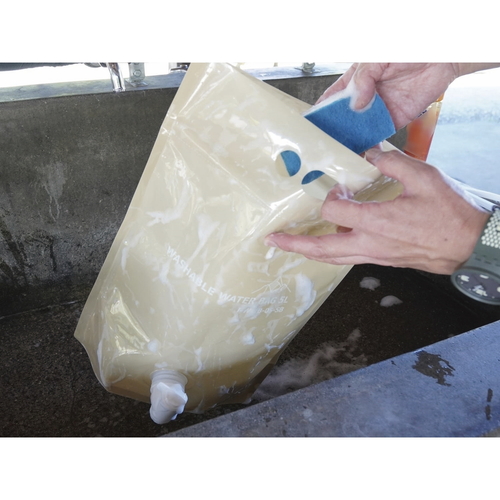 ウォータータンク　5L　折りたたみ　ウォッシャブルウォーターバッグ　サンドベージュ 折りたたまれた状態で地面に置かれた淡い色合いのバッグ