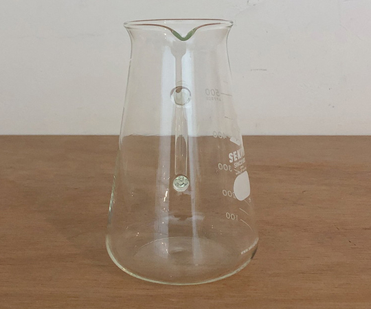 取っ手付きコニカルビーカー 500ml 透明なビーカーが右側に傾いている様子、取っ手がしっかりと見える状態。