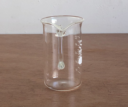 取っ手付きトールビーカー 100ml 透明な容器が正面から見える状態、取っ手が目立つ角度で撮影されています。