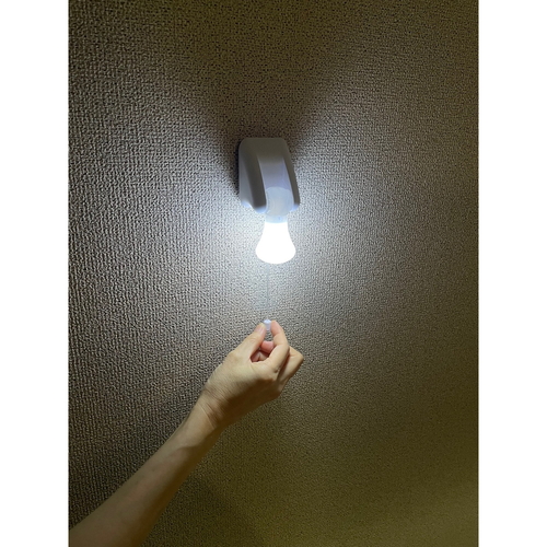 電池式ひも引きライト 透明なケースに収められた光る引き紐、底部に電源ボタン付き
