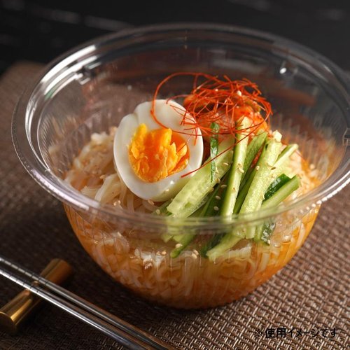 冷麺容器 バイオ BOWL本体(M) TN リスパック 透明な容器に盛り付けられた冷たい麺と具材が並ぶ様子