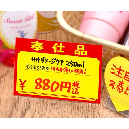 POP用紙 11-1721 黄ポスター 大 奉仕品 \ 100枚入 ササガワ 真上から撮影された、重ねられた100枚入りの鮮やかな黄色のパッケージ