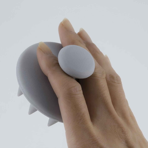 シャンプーブラシ　頭皮ブラシ　シリコンシャンプーブラシ　ライトグレー 丸みを帯びたハンドル付きで、やわらかなシリコンブラシの頭部が平面的に配置された様子