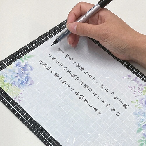 Kiwami ライティングマット下敷 A4+ ブラック 1枚 黒いマットが斜めに置かれ、光沢のある表面が際立つ様子