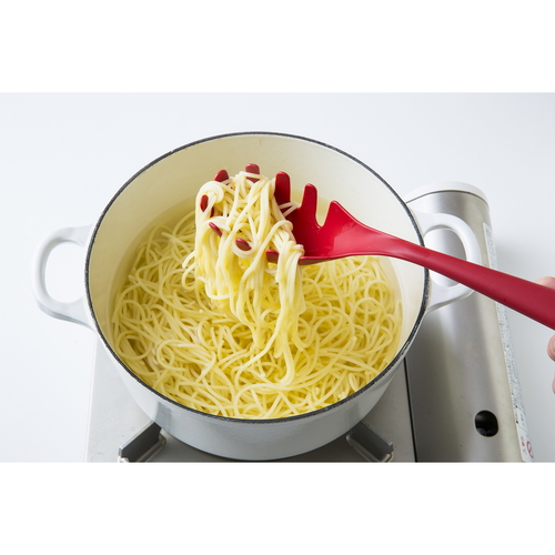 パスタサーバー　シェフツール　キャッチ麺サーバー 黒いハンドル付きの金属製サーバーが木製テーブルの上に置かれている様子