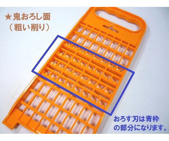 ドイツ製 CL コンビおろし器 オレンジ（おろし金） 明るいオレンジ色の本体を持つ、角度をつけたおろし器の上面が見える状態