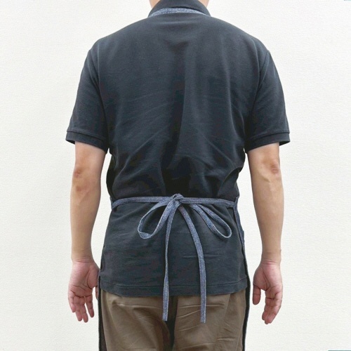 ワークエプロン 1枚 前面にポケットが配置された、シンプルなデザインのエプロンがhangされています。