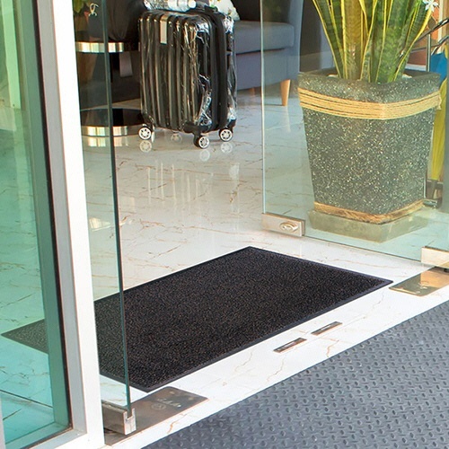 玄関マット　アイアンホース(ストライプ)　450×750mm　ブラック・ブラウン　1枚 ストライプ模様が施された縁取りのあるマットがゆったりと置かれている様子