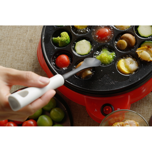 タコ焼き　スプーン　MOTTE　たこ焼きプレート用スプーン　日本製 しなやかな曲線を持つ金属製のスプーンがテーブルの上に置かれた状態