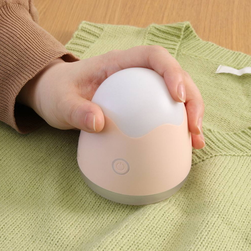 毛玉取り器　オーヴォ　充電式　ピンク コンパクトなデザインで、ピンク色の本体と充電ポートが見える状態