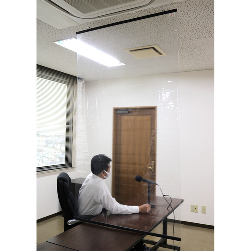 透明シート　店舗　1m　防炎　抗ウイルス抗菌　間仕切り　透明シールド材 透過したシートが、上下で固定された透明な間仕切りとして立てられている様子
