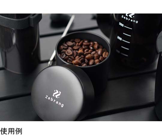 コーヒーキャニスター50G Zebrang 光沢のある金色の缶が立てて置かれ、ラベルが正面に見える状態