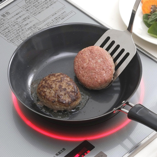 燕三条　鉄製フライパン　22cm 光沢感のある黒いフライパンがテーブルに置かれ、グリップが視認できる状態