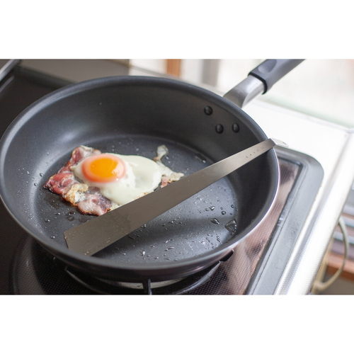 スパチュラ EAトCO いいとこ Tolu トル スパチュラ フライパン返し ターナー 持ち手部分が黒のフライパン返し、金属部分が光沢のある状態で直立している。