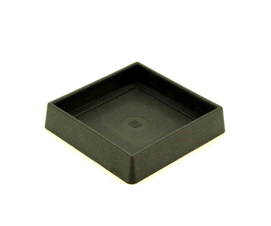イスゴム　平置　角型　黒　対象脚サイズ65mm 平らな面に置かれた黒い角型のゴムパーツ、四隅がはっきりと見える状態