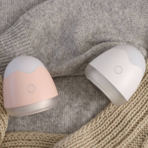 毛玉取り器　オーヴォ　充電式　ピンク 充電コードとともに横向きに置かれたデザイン