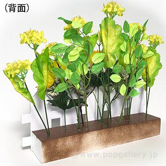 菜の花垣根アレンジ 鮮やかな黄色の花が密集したアレンジメント