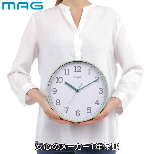 掛け時計　掛時計　ガレット　グリーン テーブルに置かれた緑色の掛け時計、針が12時を指している様子。