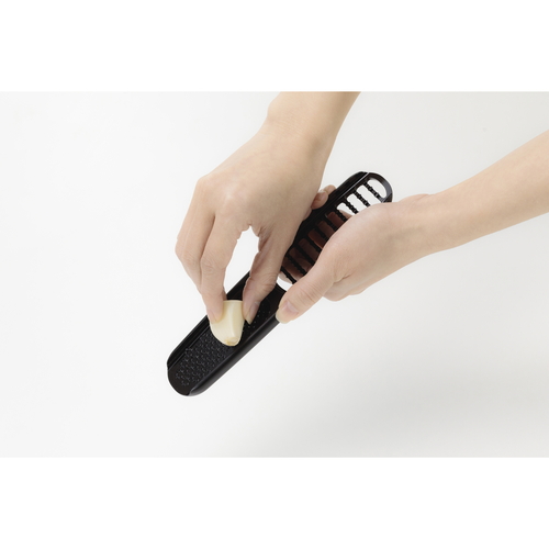 にんにくおろし器　KK　にんにくマスター 商品がテーブルの上に置かれた状態で、使い方の説明が印刷された側面が見える。