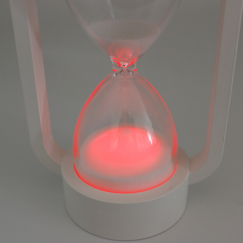 ノクティルカ　LED砂時計　10分計 透明な容器に細かな砂が満ちた、暗闇で光るLEDが点灯している様子