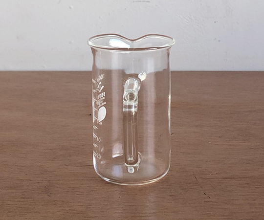 取っ手付きトールビーカー 100ml 透明な容器の内側が見え、取っ手がしっかりとした状態で水平に置かれている。