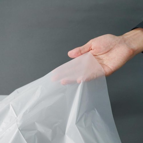 ゴミ袋 LimeAir Bag ポリ袋90L TBM 平らに広げられた透明な大きな袋が積み重ねられている様子