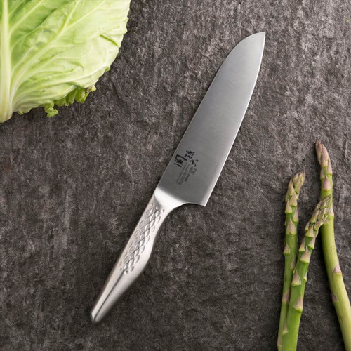 三徳包丁　16.5cm　関孫六　匠創 刃先が光り輝く新品の包丁が木製の台に置かれている様子