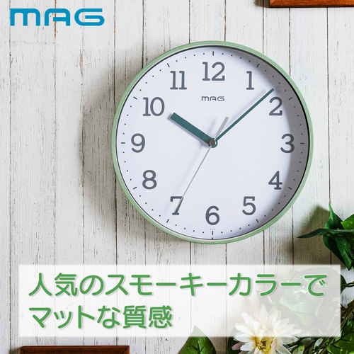 掛け時計　掛時計　ガレット　グリーン 明るいグリーンの壁に掛けられた、シンプルなデザインの時計が正面から見える状態。