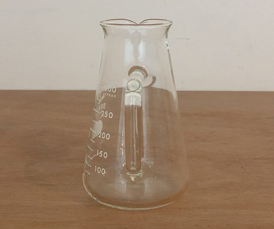 取っ手付きコニカルビーカー 300ml 取っ手が付いたビーカーの側面が正面から見える状態、透明な素材で容量が表示されている。