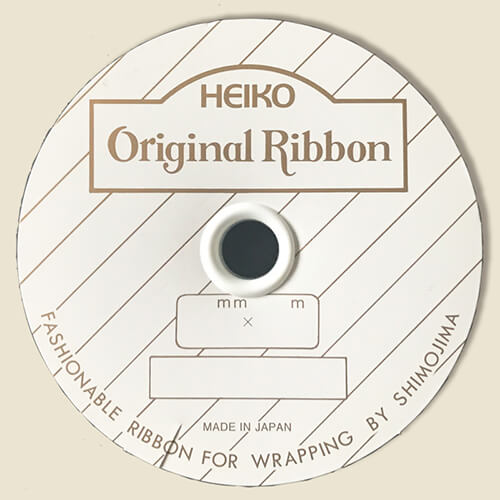 HEIKO キャピタルリボン 36mm幅×50m巻 レモン カット面を手前にして横置きされたレモン色のリボンが一本、中央に白いラベルが巻かれた状態