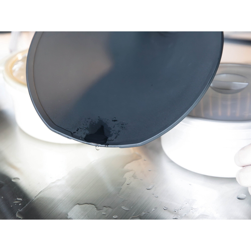 抗菌TPUまな板　半月　食洗機対応　atomico　ブラック 半月型のマナ板が黒く光沢のある質感で浮かび上がる様子