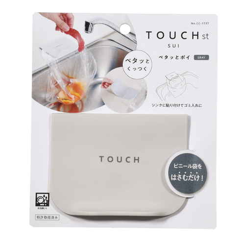 三角コーナー　ゴミ入れ　TOUCH　st　ペタッとポイ 白い壁に取り付けられた状態で、ゴミを受け入れるための口が開いている様子
