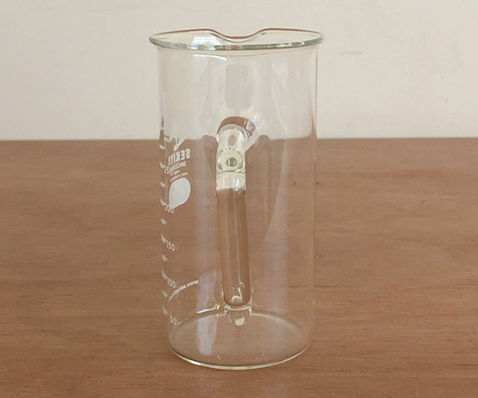 取っ手付きトールビーカー 300ml 透明な素材でできた取っ手付きの容器が横向きに置かれている様子