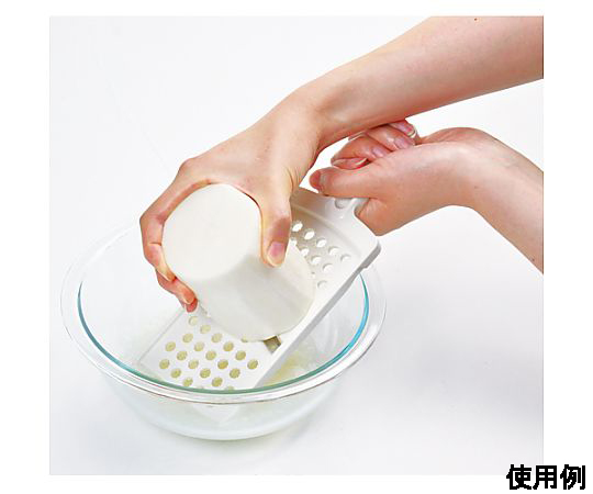 245x105x 35mm おろし器(スライサー付) 表面に凹凸があり、スライサーが側に置かれた状態