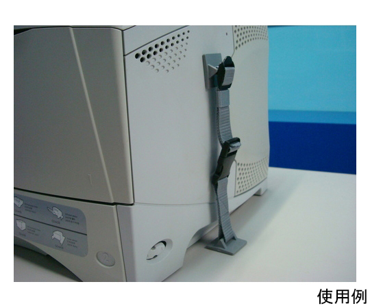 転倒防止用品 卓上プリンターストッパーTKP（2本入） 本体寸法：幅41×長さ280×高さ18mm 商品が置かれたテーブル上で、横から撮影された黒のストッパーが2本並んでいる様子。