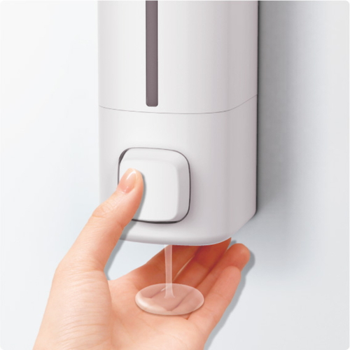 ラックス　ディスペンサー　550ml　マグネット　ホワイト 白いマグネットで壁に取り付けられたディスペンサーの側面が見える状態